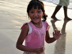 Menina na praia de Jimbaran ao entardecer